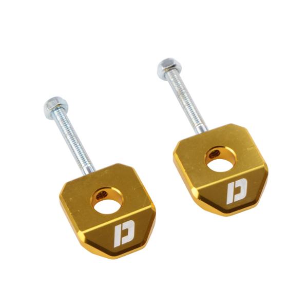 Grandinės įtempėjas MOTO CNC aliuminis DOPPLER, skirtas DERBI SENDA/SMT/RCR/RX/SX (ratlankio ašiai 12 mm), auksinis (2 vnt.).